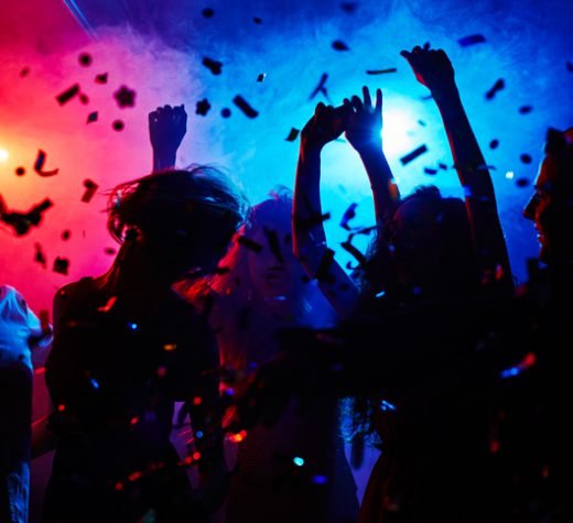 Silhouettes of dancers moving in confetti