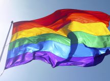 Big rainbow flag is waving in the wind with sun shining throughMore of my flag images: